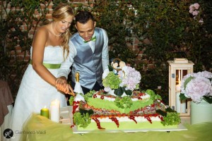 marito e moglie tagliano la prima fetta della torta del matrimonio