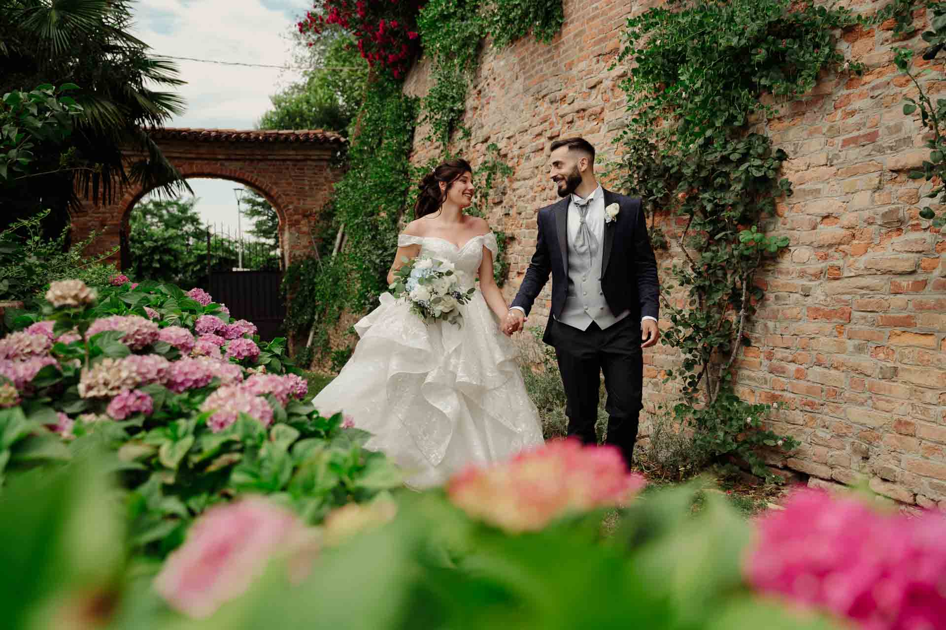 coppia sorridente e spensierata mano nella mano durante il servizio fotografico matrimoniale